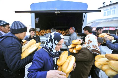 Ercis residents collect loaves of bread provided by relief agencies on Monday.