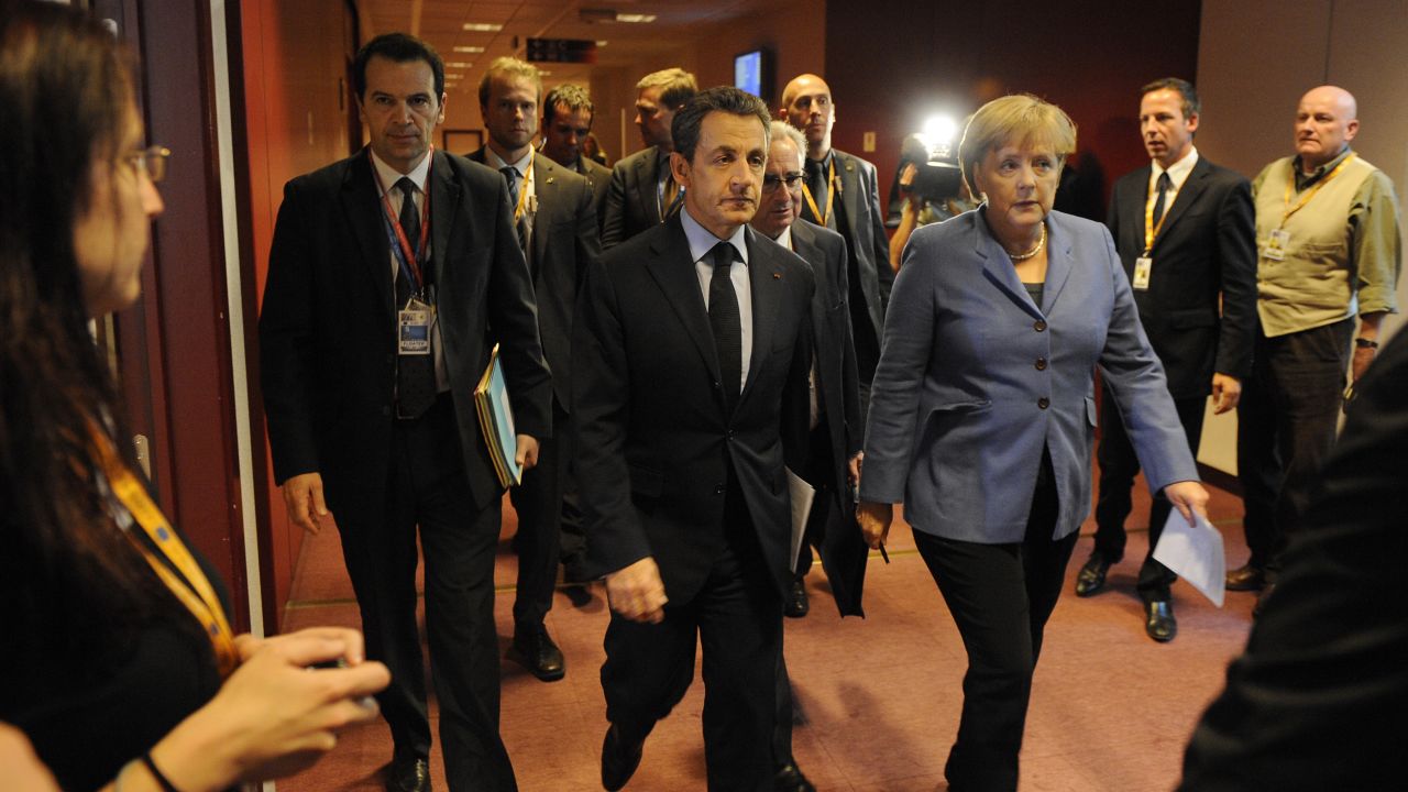 German Chancellor Angela Merkel (C) and French President Nicolas Sarkozy (L) walk in a corridor on their way to a joint press conference as part of the European Council on October 23. 