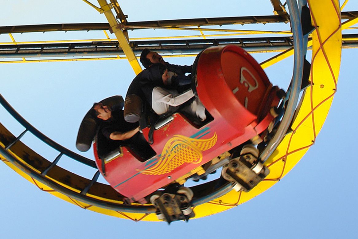 Riders grimace as the soda-can roller coaster negotiates a tight loop.