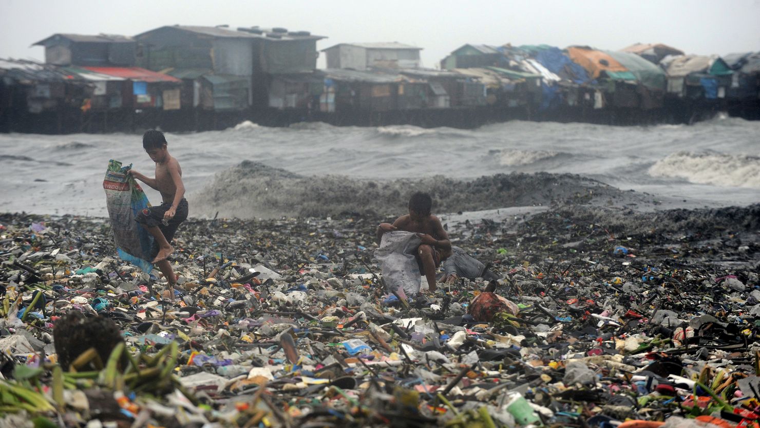 Children looking for usable materials among the garbage after a typhoon in Manila Bay, Philippines.