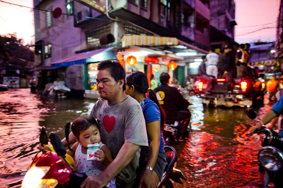 Chinatown residents make their way through a flooded street on Wednesday. The water has caused problems for small vehicles and led to traffic congestion.