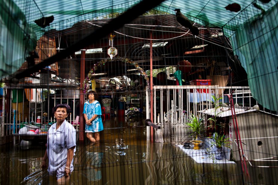 Women stand in a flooded residential area in Bangkok's Chinatown. Overall damage from the floods could top $6 billion, the Thai Finance Ministry said.