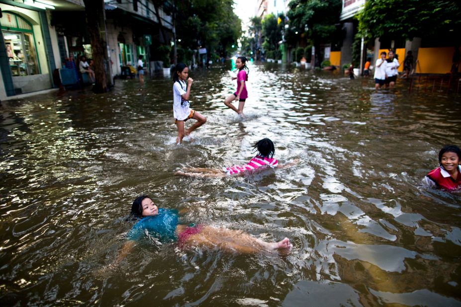Children play in flooded streets in Bangkok. It might take more than a month for the waters to recede in some areas, officials say.