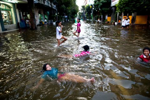 Children play in flooded streets in Bangkok. It might take more than a month for the waters to recede in some areas, officials say.