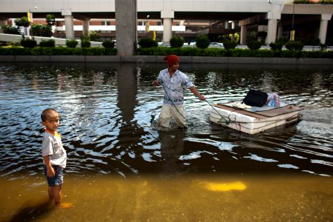 A man pulls a makeshift raft through a flooded street in Bangkok on Wednesday. Floodwaters extend from Rangsit, north of Bangkok, to the Don Muang airport and Yingcharoen Market.