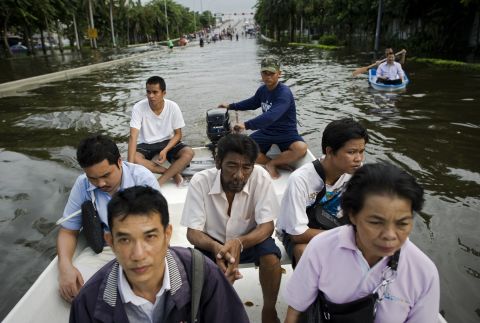People travel through floodwaters on a boat as they evacuate their neighbourhood next to the Chao Praya river in Bangkok..