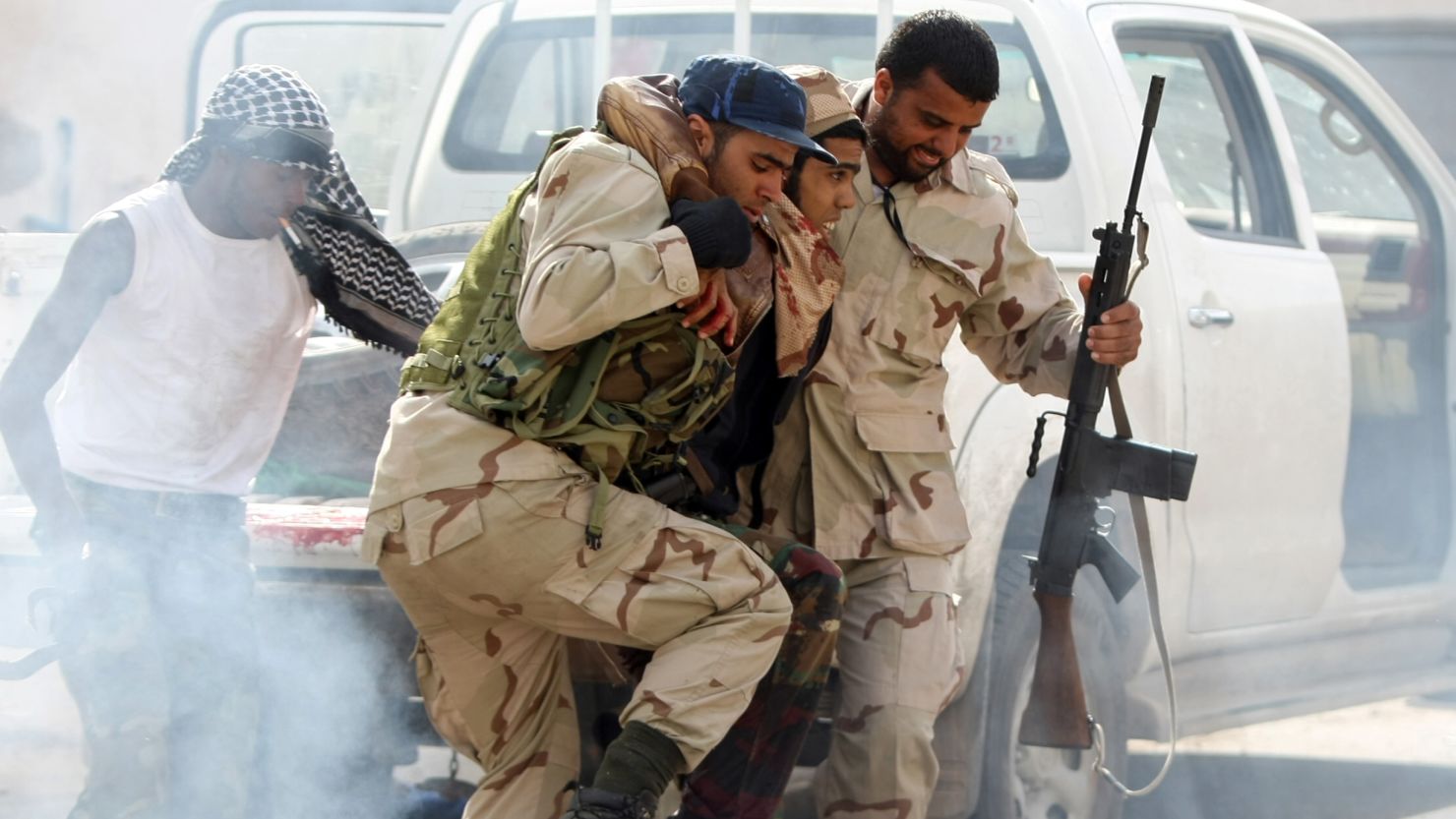 Libyan NTC fighters take a wounded comrade to a field hospital in Sirte on October 18. 