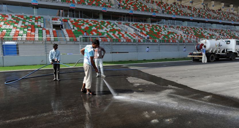 Journalists reported that the finishing touches were still being put on the the circuit this week. Here workers wash the track.
