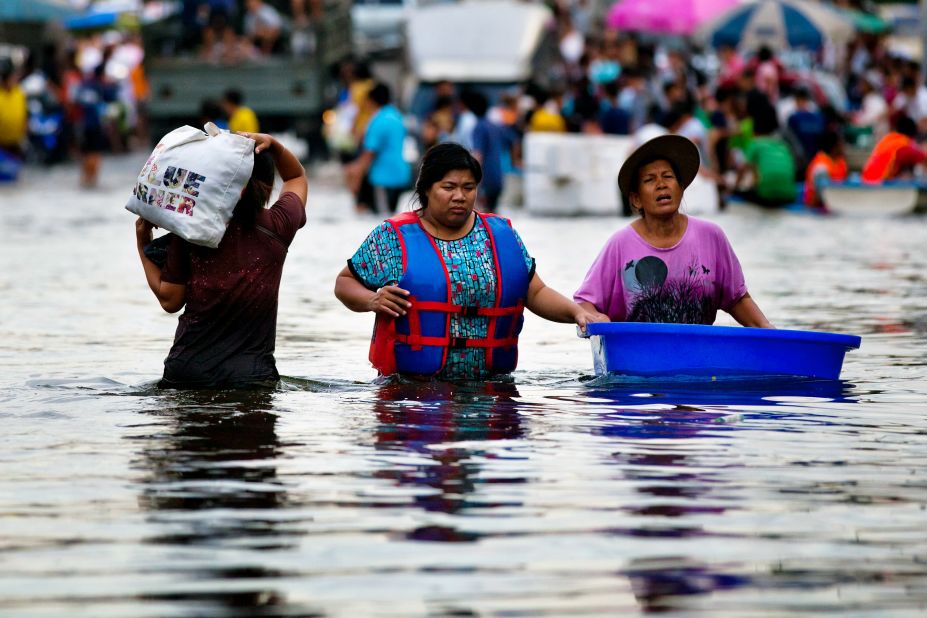 Thai residents wade through waist-high waters in Bangkok on Friday, October 28, after heavy floods swept through the area. Hundreds of people have died from flood-related incidents since July.