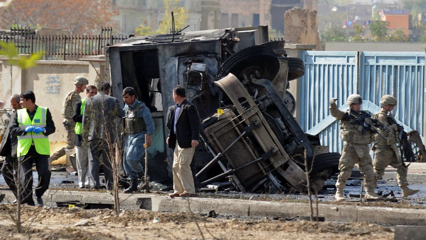 Afghan security forces and NATO troops inspect the site of a suicide attack in Kabul on Saturday.
