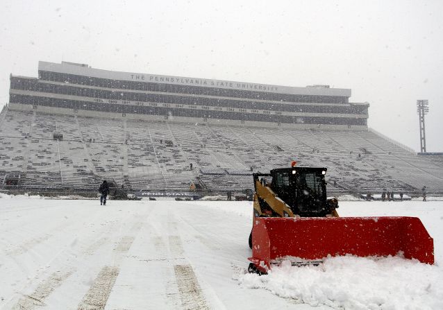 A snowplow removes snow from Penn State University's Beaver Stadium on Saturday. The early season snowstorm was the result of unseasonably cold air mixing with a storm system on the East Coast.