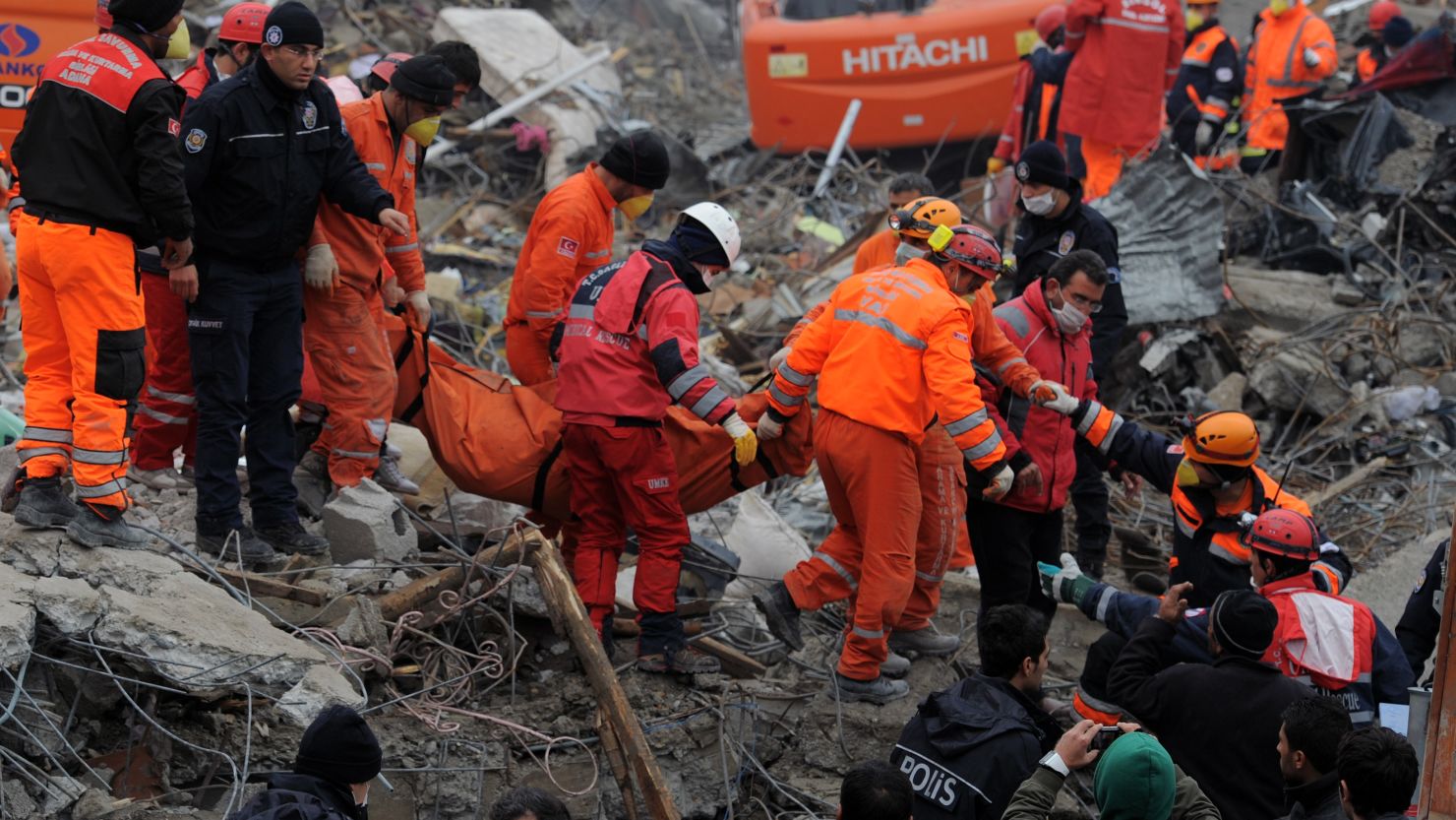 Rescue workers carry the body of a victim in Ercis, Turkey, on Thursday, after an earthquake shook the area.