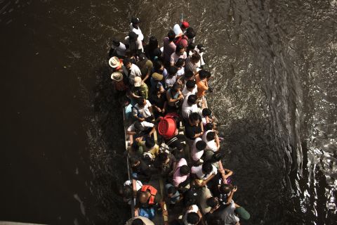 People travel on a truck along a flooded street on Sunday in Bangkok.