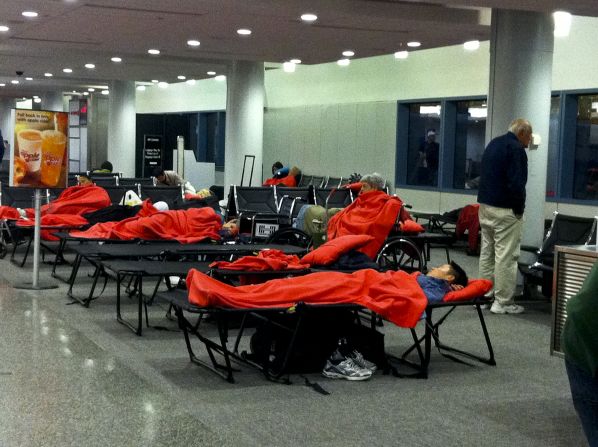 JetBlue passengers stranded in Hartford, Connecticut, sleep on floors and cots at the airport. They had to line up to get new seats on their diverted flights.<br />