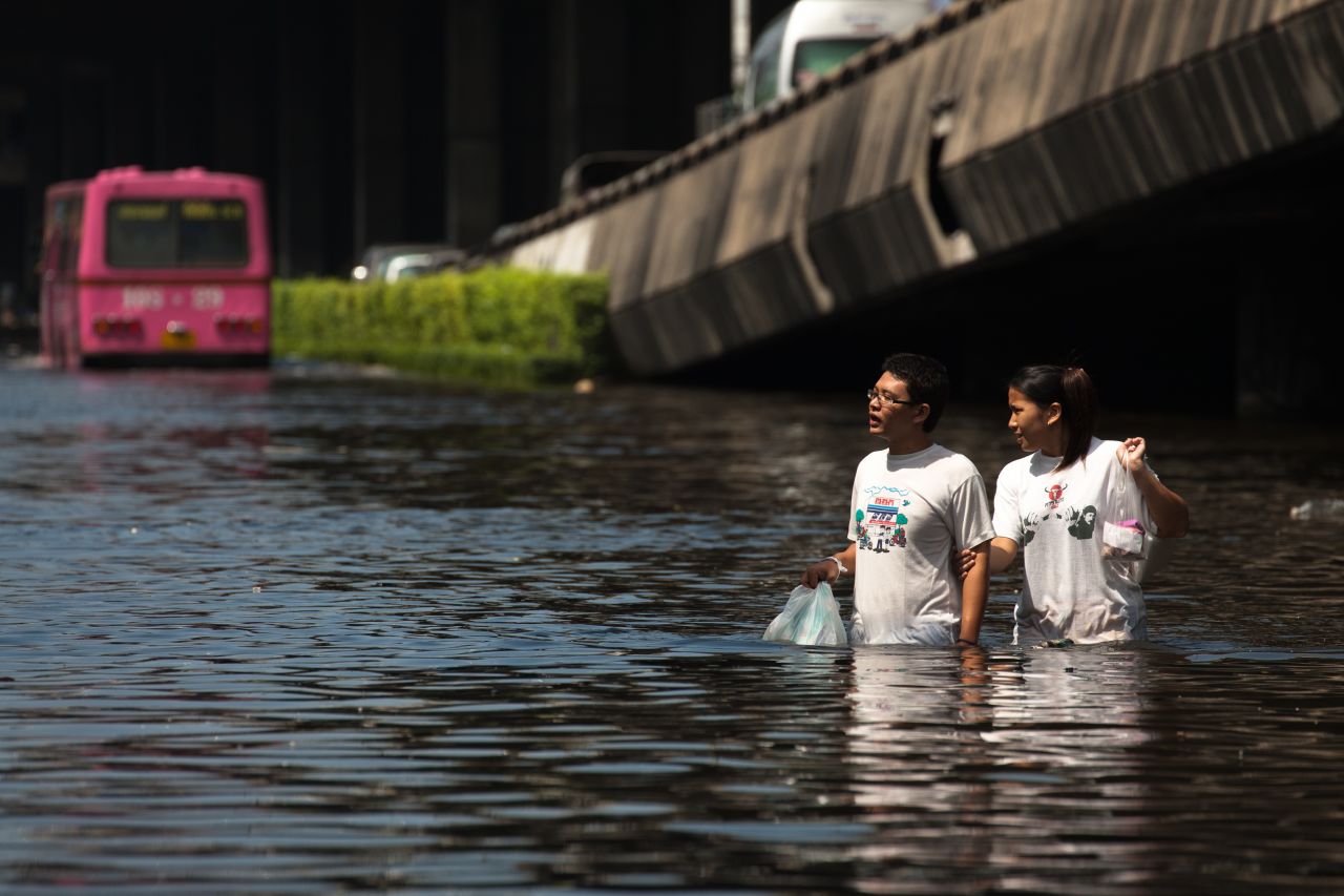 Residents  commute along a flooded street on Sunday.