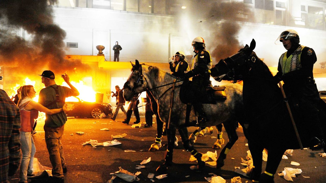Police on horseback try to move an unruly crowd in June in Vancouver, British Columbia, Canada.