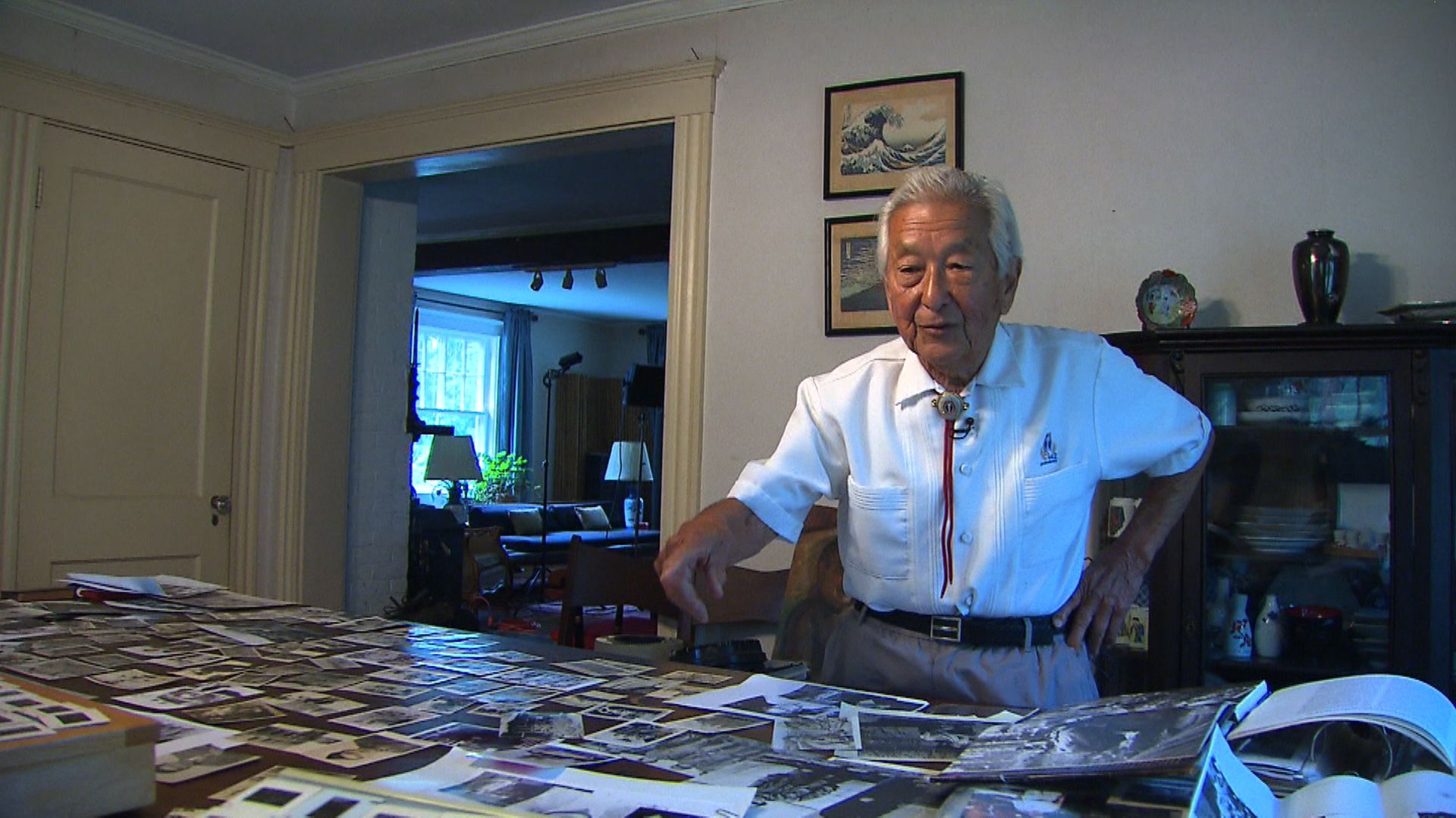 Susumu Ito displays the large number of photos he took in Europe during his US Army service in WWII