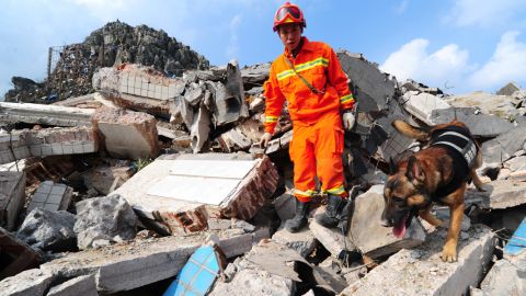 A firefighter in Fuquan searches through debris after two trucks carrying explosives detonated. 