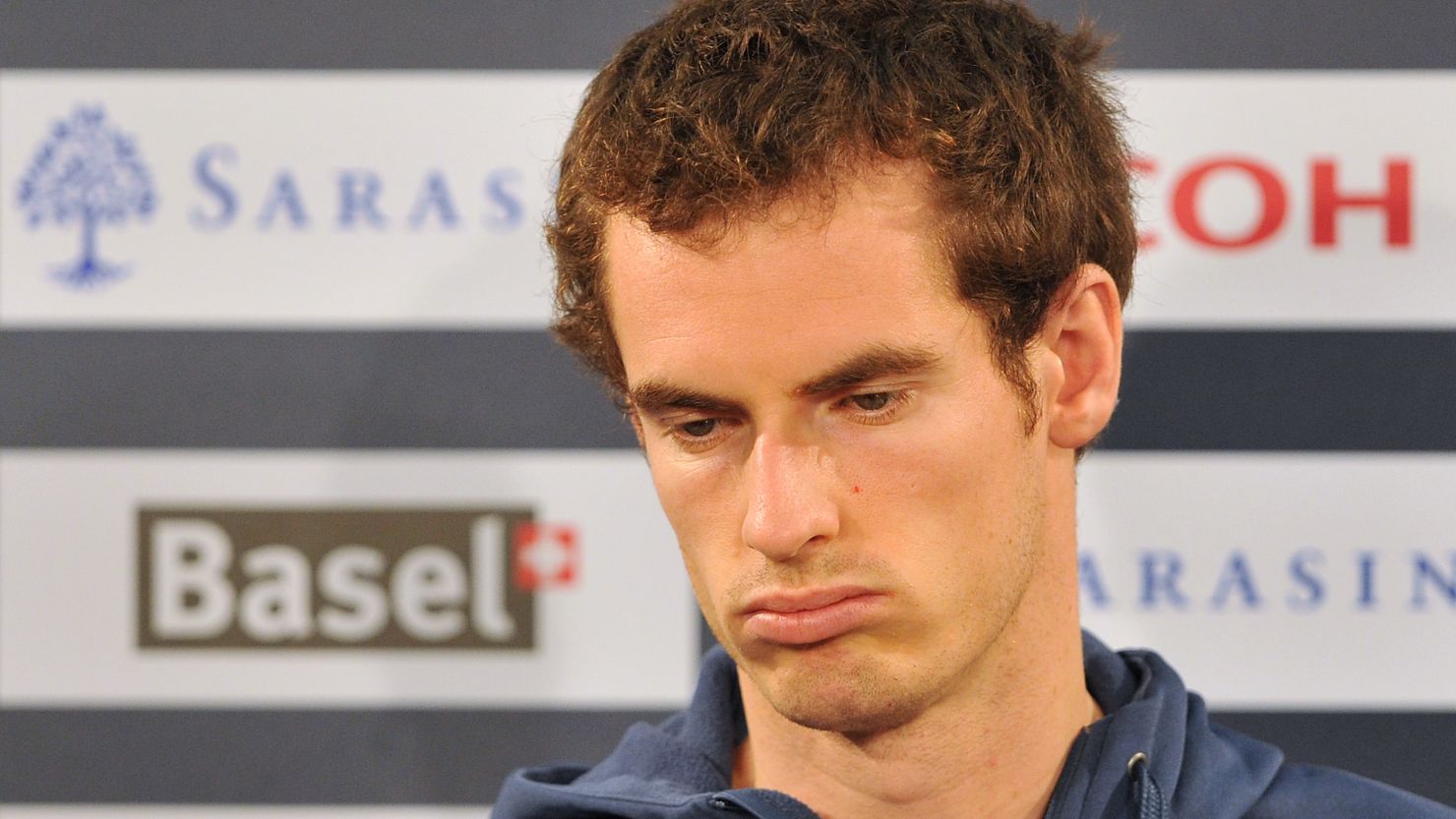 Andy Murray looks dejected as he announces his withdrawl from his first-round match at St. Jakobshalle.