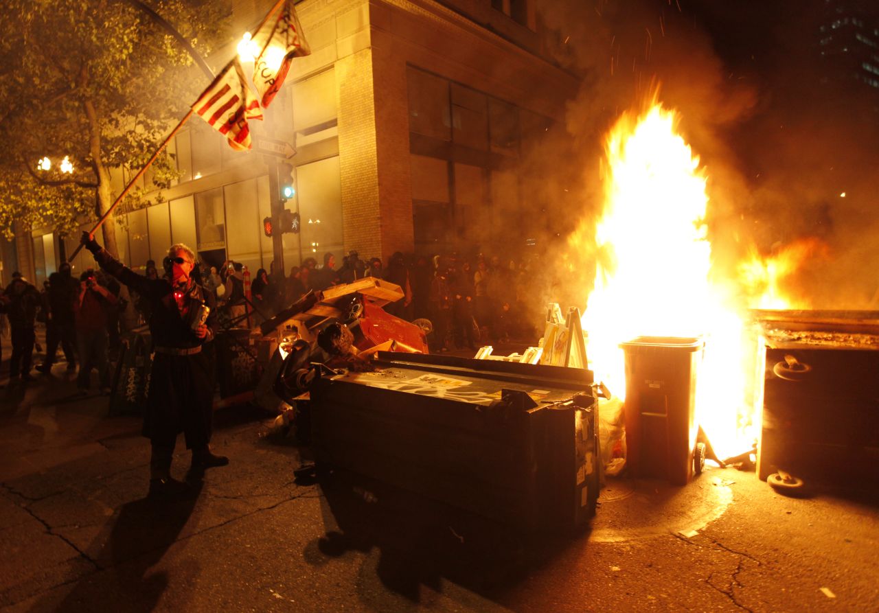 Occupy Oakland protesters set fire to trash to make a barricade against police early Thursday. Police said they surrounded and arrested dozens of protesters wielding shields.