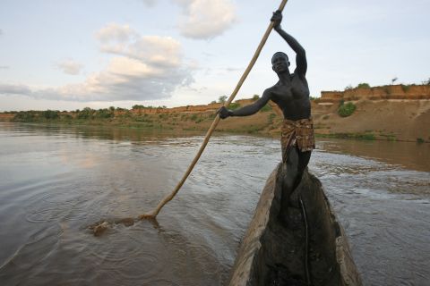 Kara tribe member Bona Shapo navigates his way across the Omo River in a boat made out of a hollowed log. Shapo says the river is a place where some of the mingi killings take place. "Sometimes they take the babies out in a boat. Other times, they just take them to the edge of the water and throw them in."