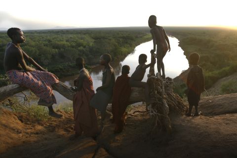 Children from the Kara tribe gather near the Omo River at dawn. None of them are considered "mingi." 