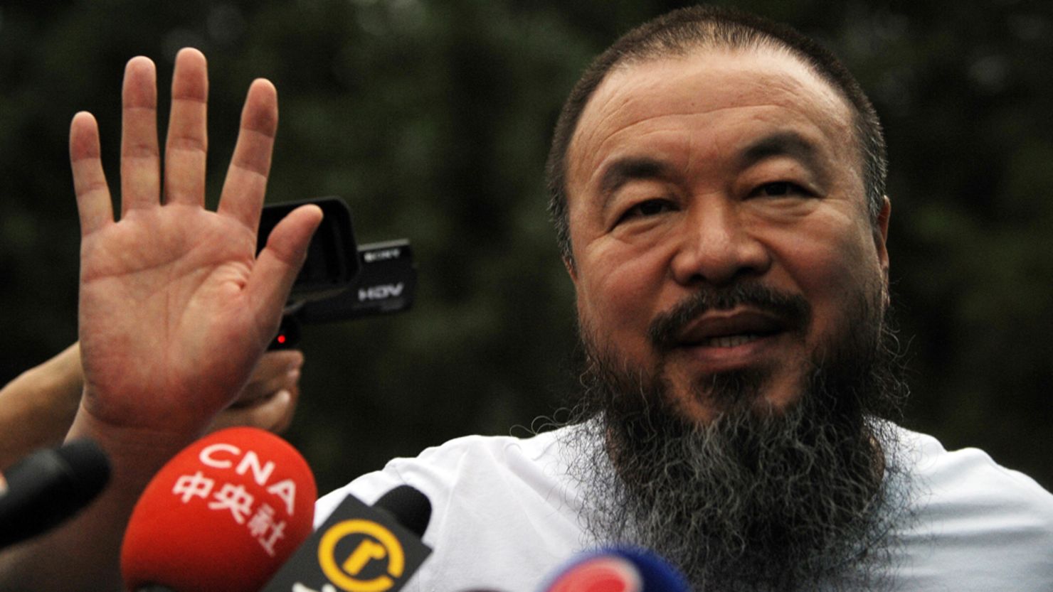 Chinese artist Ai Weiwei speaks to reporters outside his studio in Beijing in June earlier this year. 