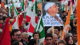 Demonstrators hold a placard with a portrait of Italian Prime Minister Silvio Berlusconi and reading "The playboy above suspicion" during a protest Saturday in Rome