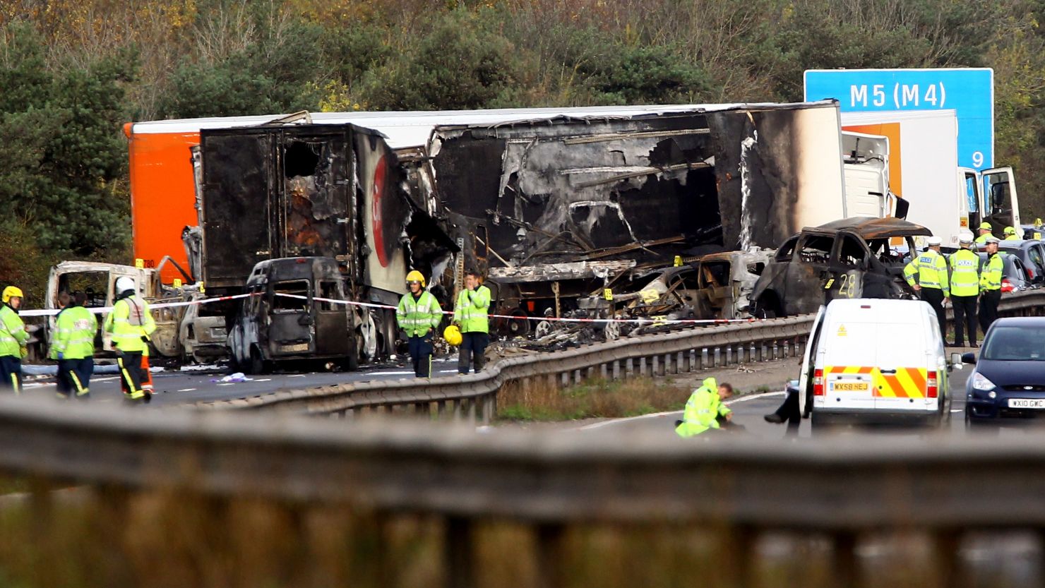 Workers attend the scene of a multivehicle crash on the M5 motorway on Saturday in Taunton, England.