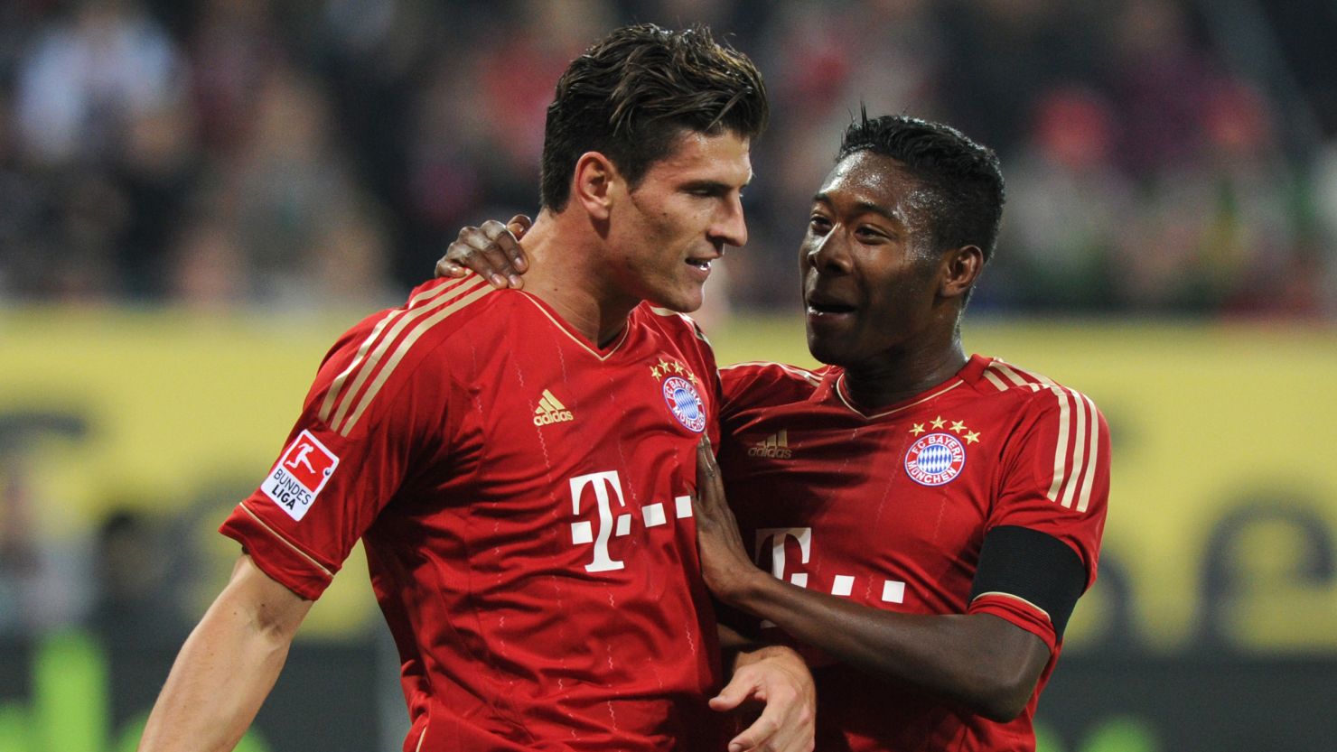 Mario Gomez (left) celebrates scoring his 20th goal of the season as Bayern won 2-1 at  Augsburg.