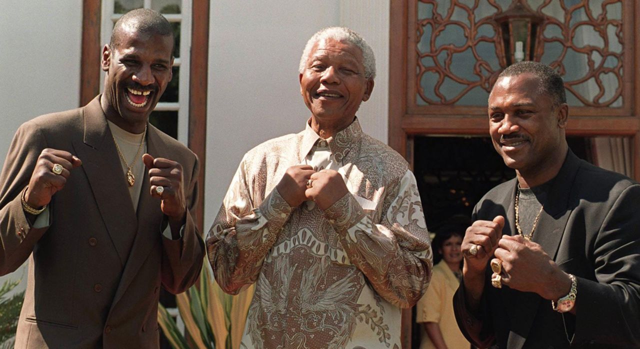 Then South African president Nelson Mandela poses with former heavyweight boxing champions Michael Spinks, left, and Frazier in Pretoria in 1997.  