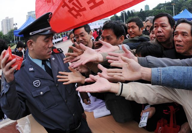 A group of Chinese men gather to collect the free condoms distributed to mark World AIDS Day in Fujian province on December 1, 2010.