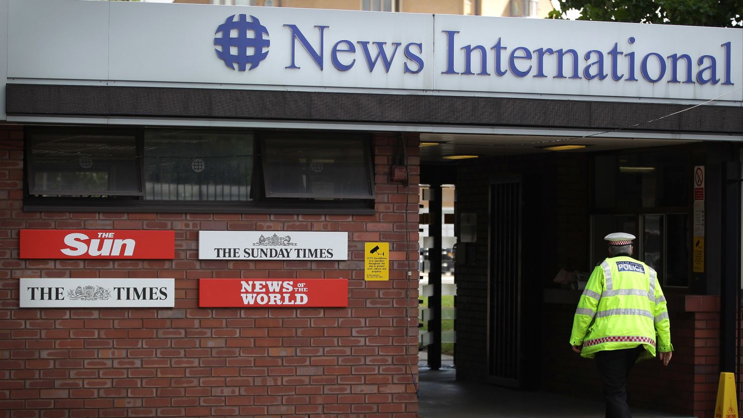 A policeman walks through the security gates at News International's Wapping plant on July 7. 
