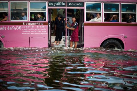People stand on a bus as it makes its way through floodwater in the Lat Phrao district of Bangkok, November 7.
