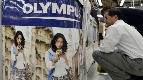 A customer checks a camera of Japanese optical giant Olympus at a Tokyo camera shop on October 27, 2011. 