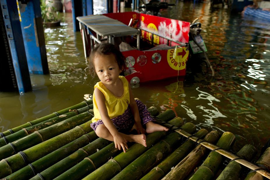 A baby sits on a bamboo raft in flood waters in Lat Phrao shopping and business district in Bangkok on November 7.