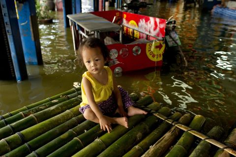 A baby sits on a bamboo raft in flood waters in Lat Phrao shopping and business district in Bangkok on November 7.