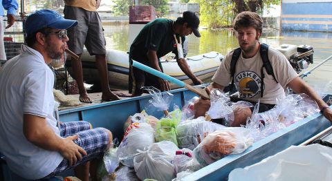 Romeo and Alex load up the boat and spend all day distributing supplies, from food and water to clothes and books, to those they come across.