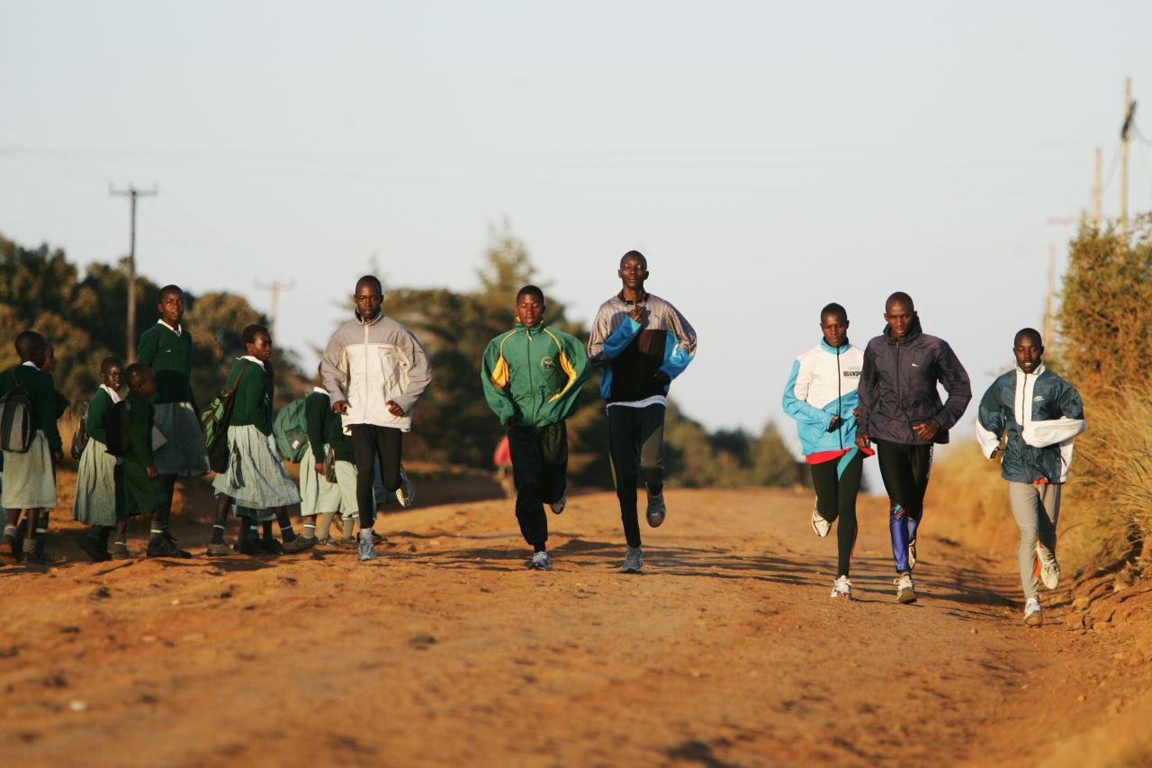 Young athletes from the Kip Keino High Performance Training Centre run past schoolchildren in Eldoret, Kenya.