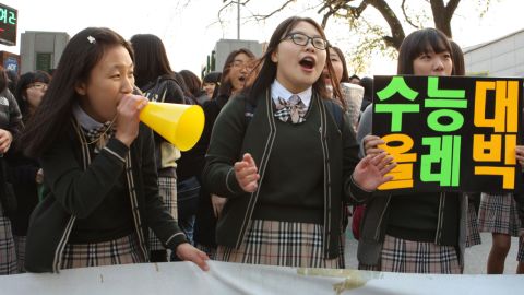 South Korean students cheer on their high school seniors who are taking their college entrance exams. 