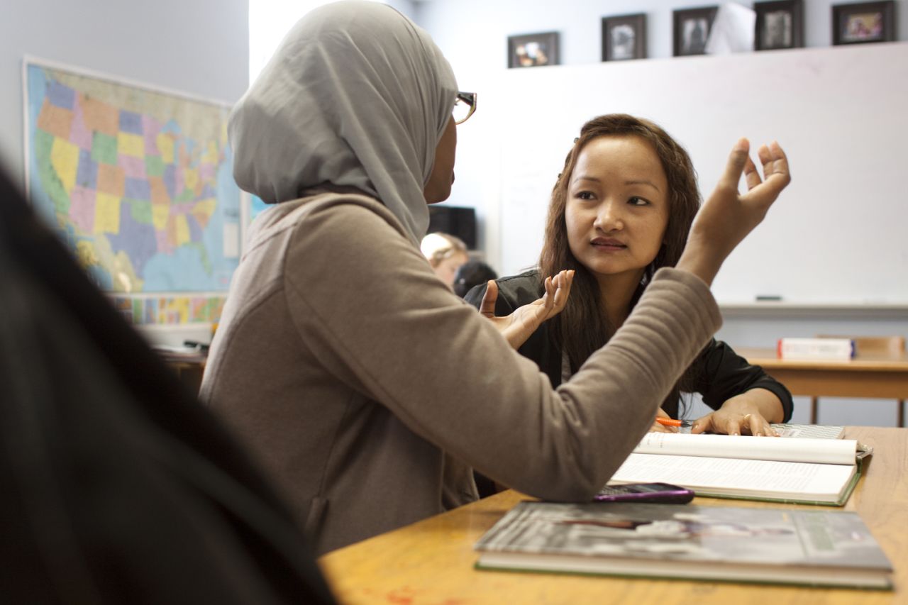 Melody, right, works with a tutor in reading class as she learns English. Melody says reading is her favorite subject.