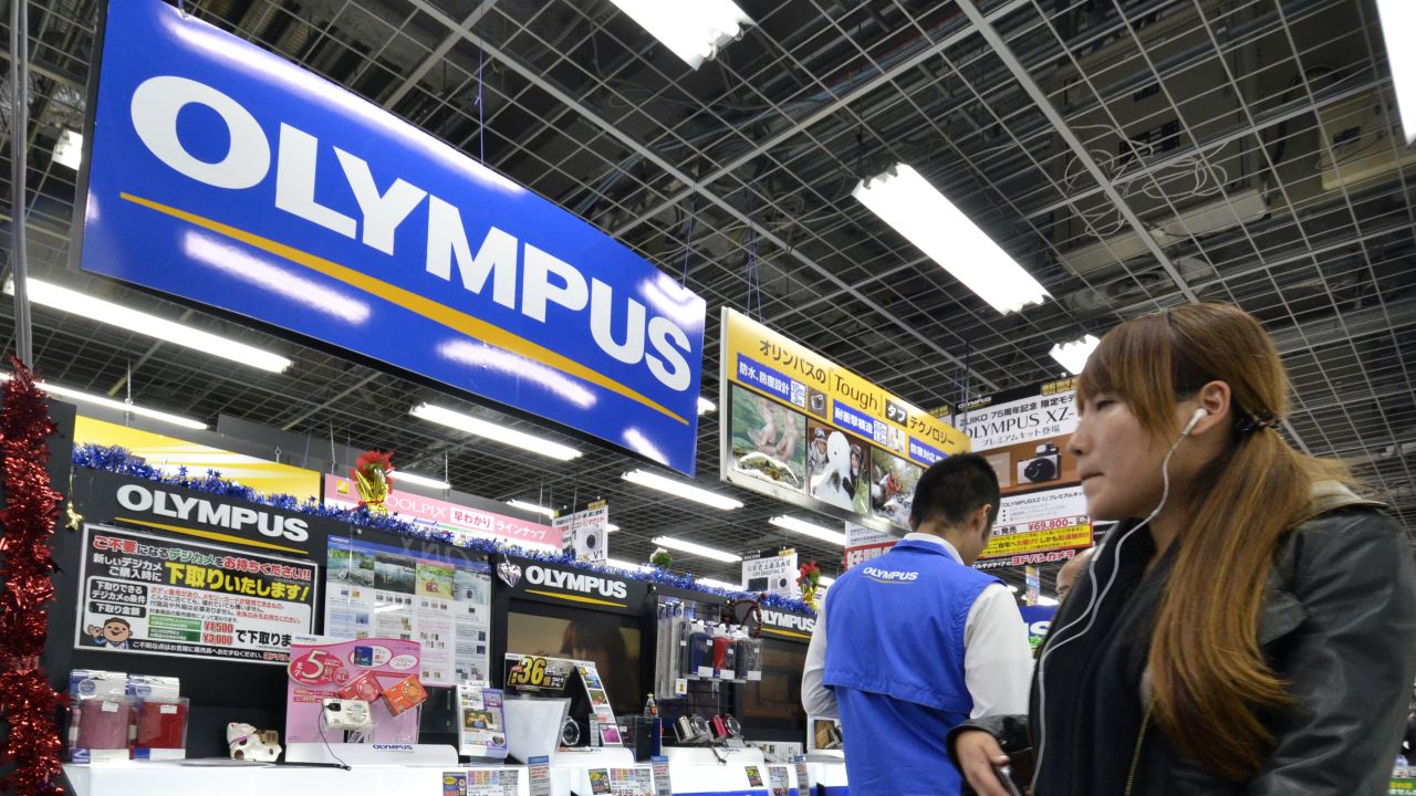 A customer looks at the Olympus booth at a camera shop in Tokyo on November 10.
