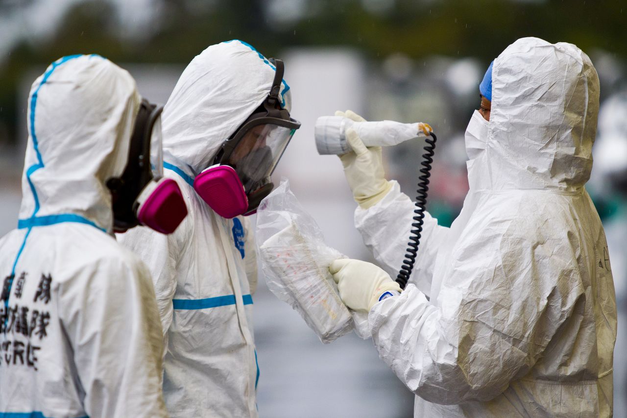 Workers dressed in protective suits and masks are checked for radiation outside a building at J-Village, a soccer training complex now serving as an operation base for those battling Japan's nuclear disaster in Fukushima.