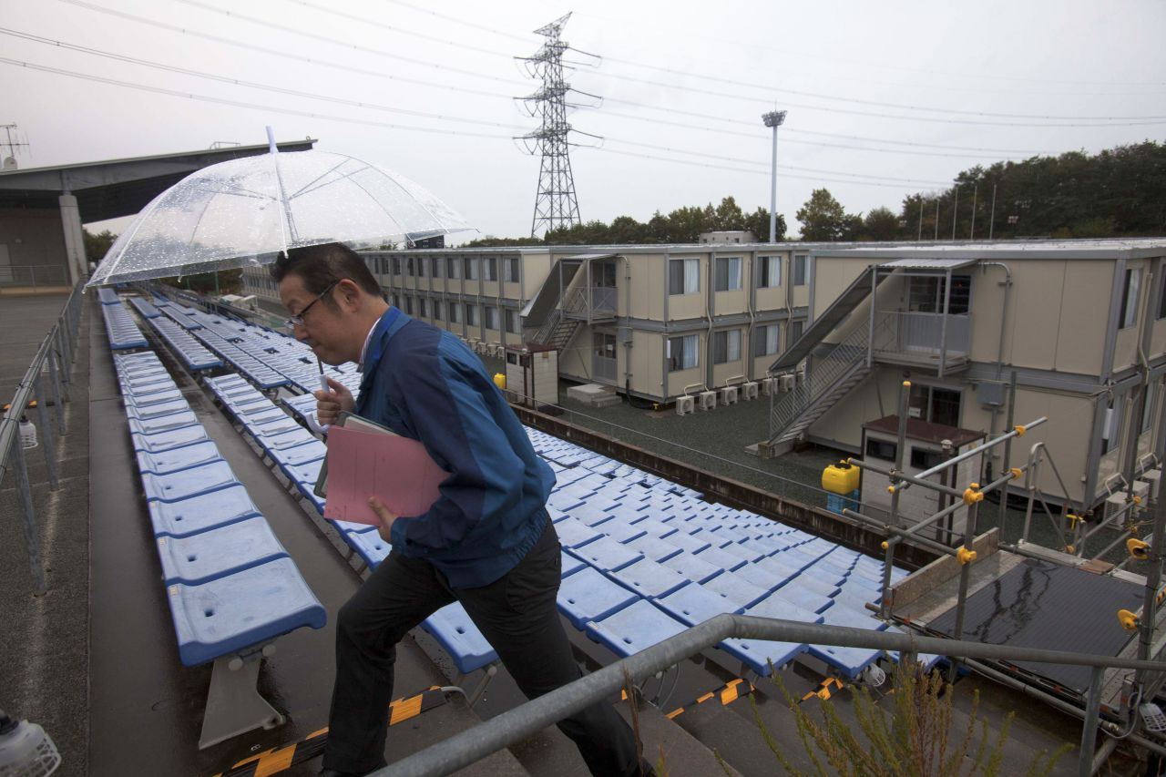 A employee of the Tokyo Electric Power Company walks up stairs near temporary housing built for workers who live at J-Village,  at the former soccer training complex.