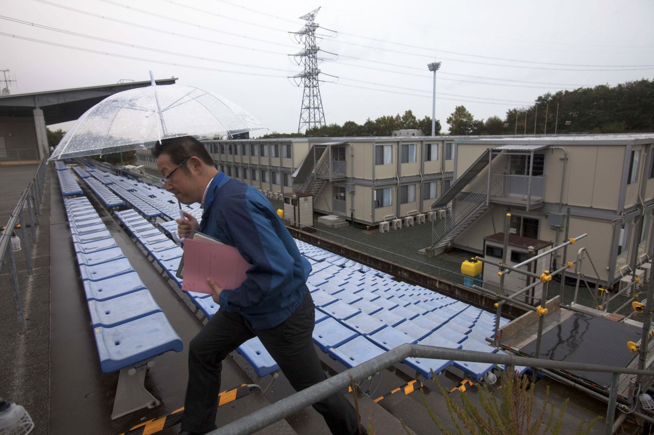 A employee of the Tokyo Electric Power Company walks up stairs near temporary housing built for workers who live at J-Village, at the former soccer training complex.