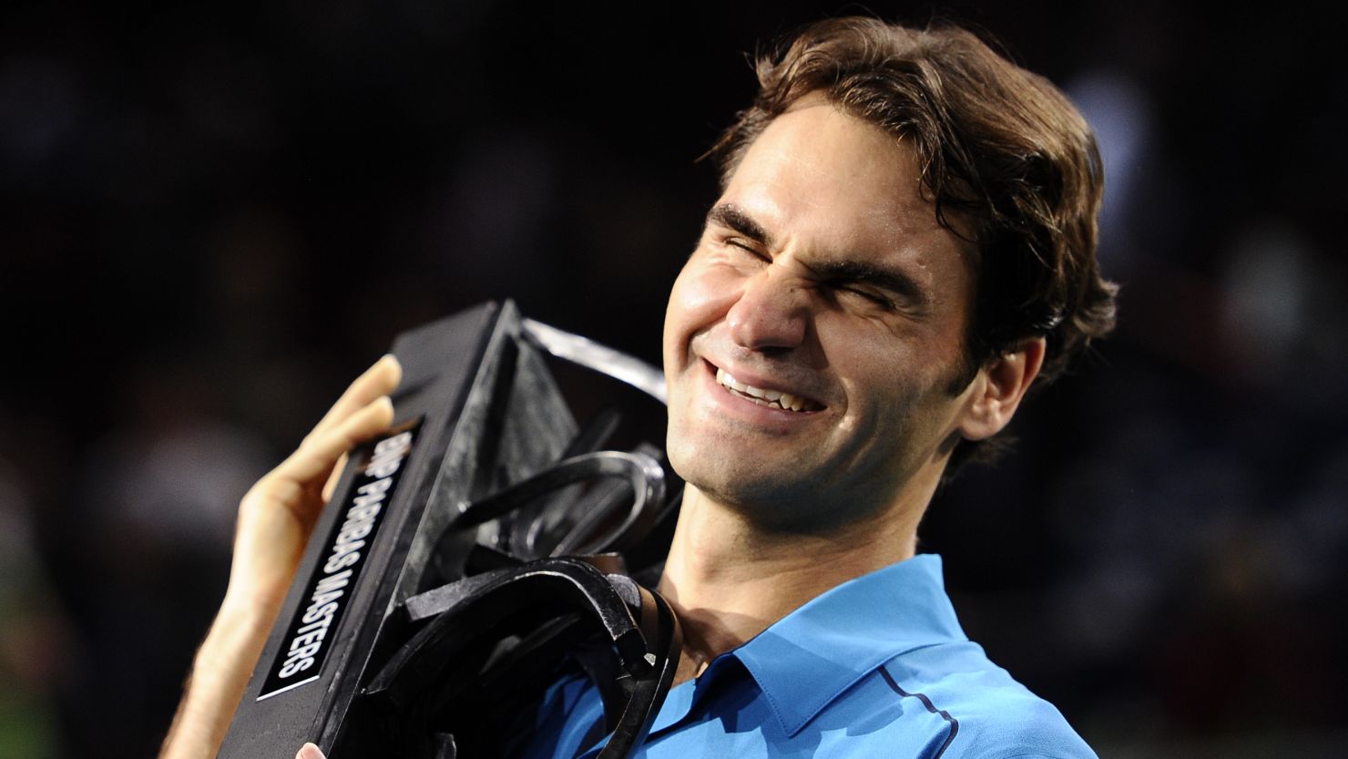 Roger Federer smiles as he lifts the Paris Masters trophy for the first time in his illustrious career.