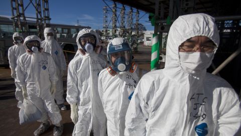 Workers in protective suits and masks wait to enter the emergency operation center at the crippled Fukushima Dai-ichi nuclear power station in Okuma on November 12, 2011.