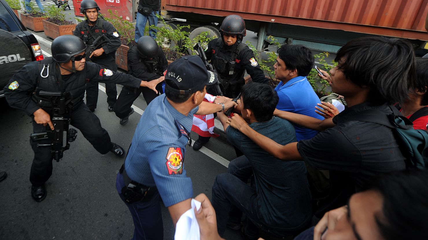 Police clash with Philippine protesters Wednesday as they block the path of Secretary of State Hillary Clinton's motorcade.