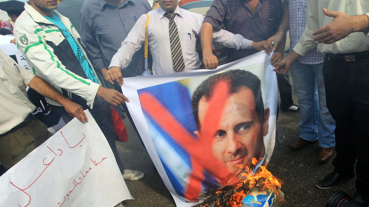 Protesters burn portraits of Syrian President Bashar al-Assad outside the Arab League headquarters in Cairo on November 12.