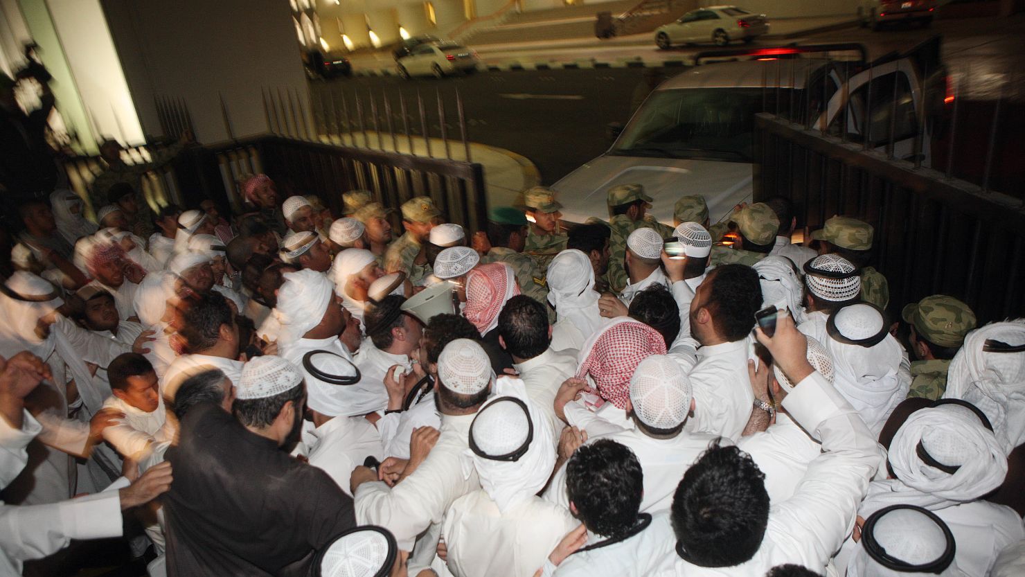 Protesters break open the gate as they storm the Kuwaiti National Assembly in Kuwait City on Wednesday.